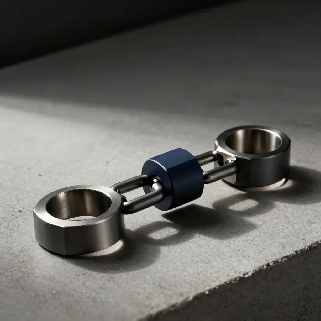 Machined rings, graphite blocks, and a coupling bracket on concrete in dramatic studio light.
